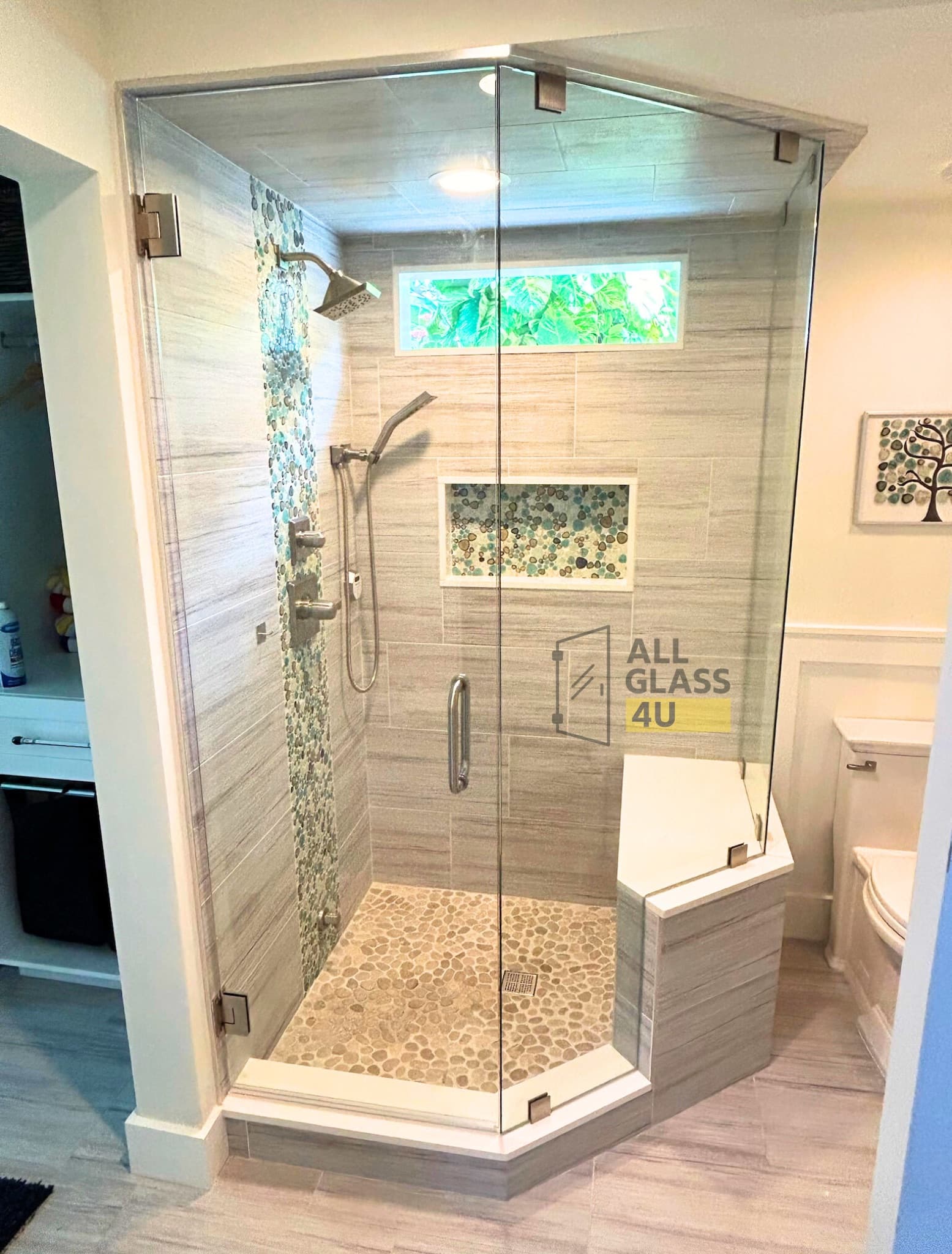 Neo-angle frameless steam shower enclosure with a pebble floor and corner bench
